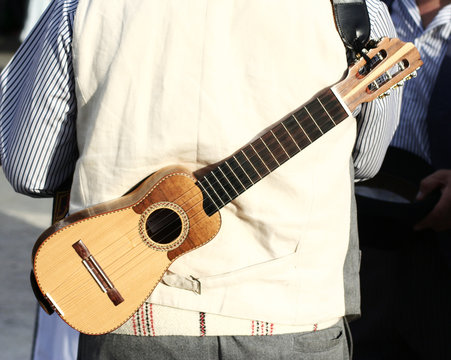 canarian man carrying traditional timple (small violin)