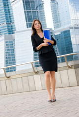 Successful business woman walking against the modern downtown.