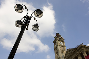 Fototapeta na wymiar city clock tower and black lamp post