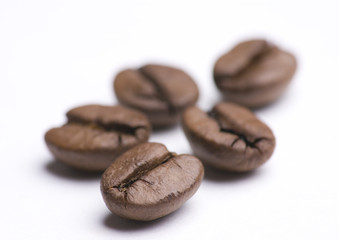 Close up of group of coffee beans on white background