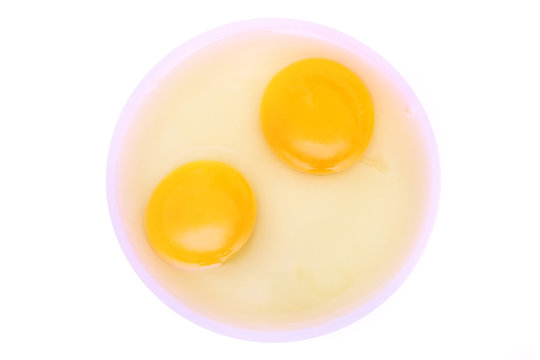 Two yolks with albumin over white background.