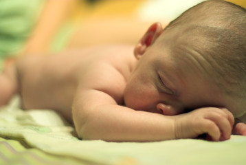 Baby is sleeping lying on his hand. Shalow depth of field.