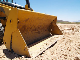 A construction Bulldozer shovel at rest.