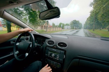 Driving a car on a wet, rainy road