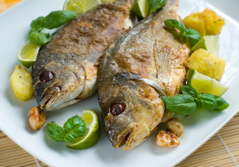 Baked gilt-head garnished with basil and green lime