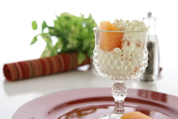 Cottage Cheese with cantaloupe (sugar melon) and cracked black pepper in crystal cut dish.