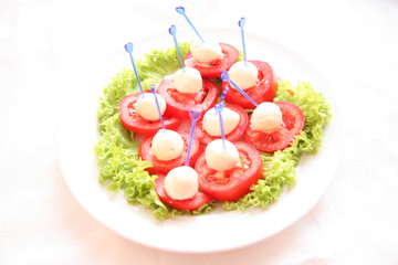 Close-up of red tomatoes and salad leaves, high key