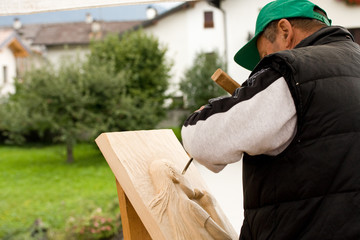uomo che scolpisce il legno