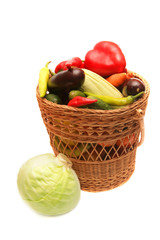 Vegetables in wood basket isolated on white.