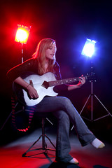 woman singing and playing guitar on stage