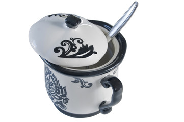 A sugar bowl with a spoon ready to sweeten your coffee