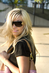 Blonde woman wearing dark design sunglasses on a