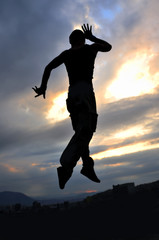 young man dancing and jumping  on top of the building