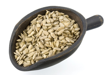 shelled sunflower seeds on a small, wooden scoop