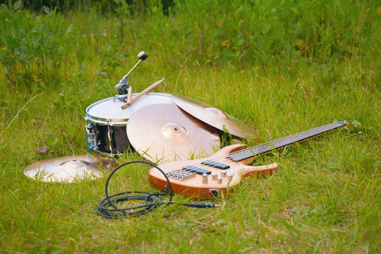 musical instruments, guitar, drum, plates on grass.