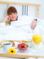 Obraz na płótnie Canvas Beautiful woman eating breakfast in bed