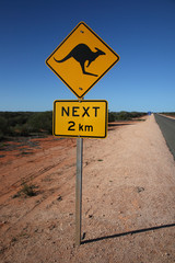 Yellow kangaroo 2 km sign, empty roads of Australia