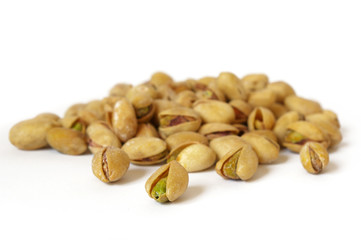 Heap of salty pistachios isolated. Soft focus