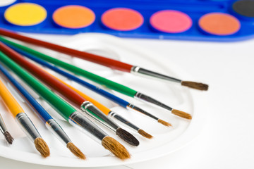 Obraz premium Water colour paints and brushes on a white background
