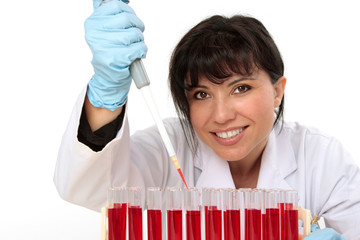 biologist, holding a pipette with sample from test tubes.