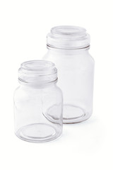 Two empty glass jars side by side on white background