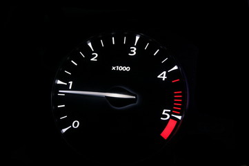 moving revs meter of a sports car on a black background.