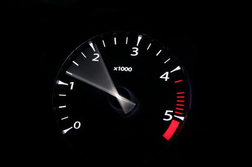 moving revs meter of a sports car on a black background.