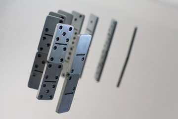 Steel dominoes in a row with reflection in polished surface