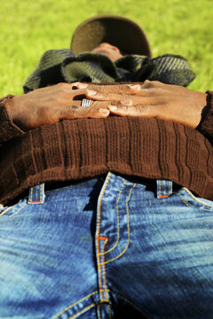 man laying on grass wearing blue jeans