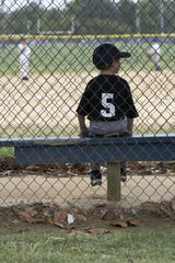 a baseball player on the bench in dugout at a game
