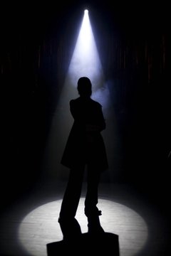 A silhouette of a person under an entertainment light.