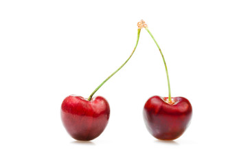 Two cherries against white background