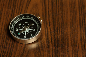 Fototapeta na wymiar magnetic compass with wooden background