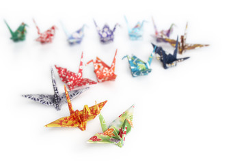 A queue of origami birds on a white background