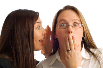 Gossiping businesswomen with amazed expression on white