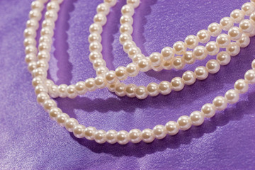 Obraz premium Beads of pearl on the lilac for lady