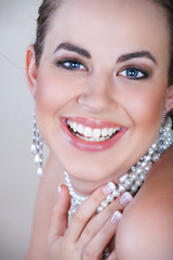 Young woman with pearl earrings and necklace laughing