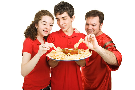 Handsome teen boy serves chips at a football party.