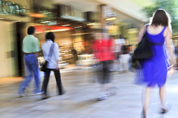 People shopping in a mall, panning shot, intentional motion blur