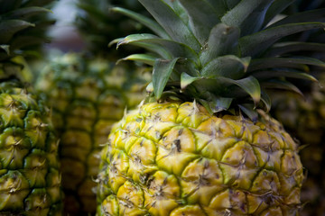 Close up image of a pineapple with pineapples in the background.