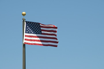 United Sates flag waving against a clear blue sky