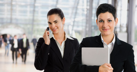 businesswomen at office lobby calling on mobile phone