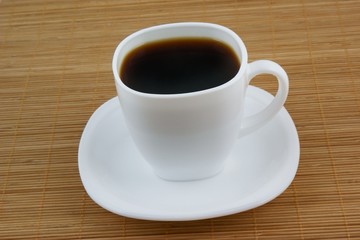 White cup of coffee on wooden background