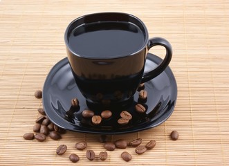 Black cup of coffee with coffee grains