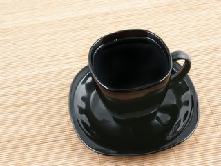 Black cup of coffee on wooden background