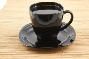Black cup of coffee on wooden background