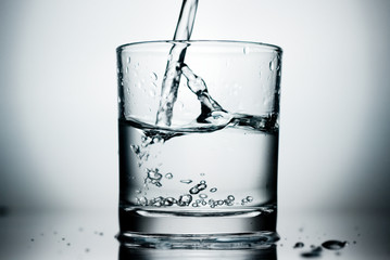 Pure water pouring into a glass.