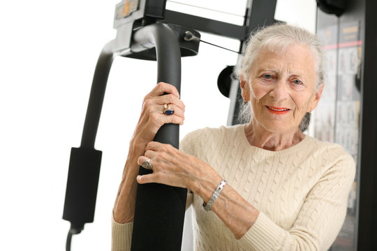 Senior Woman With Fitness Machine Over White Background