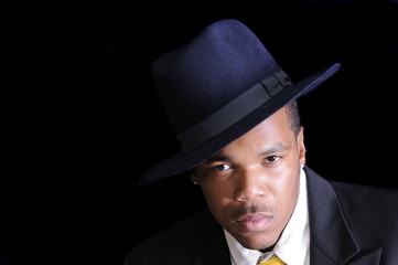 young African American man in a hat and suit