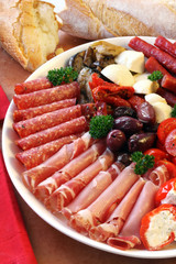 Platter of antipasti appetizers, with crusty bread.
